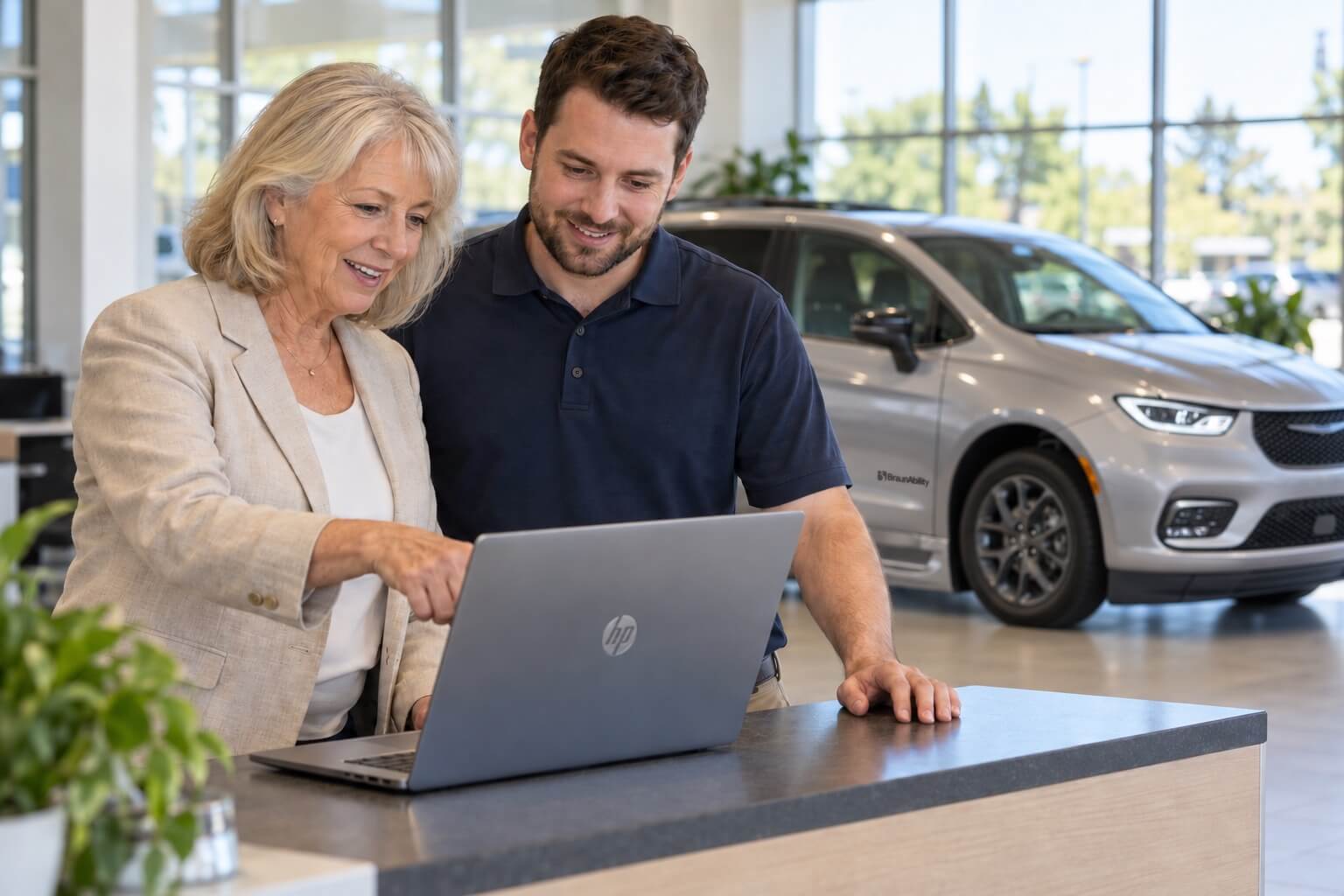 An owner and a staff member looking at a laptop together at the front counter.